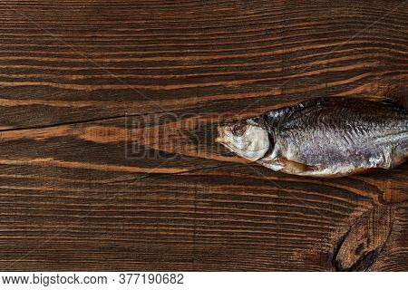 One Dried Or Jerky Salted Roach, Tasty Clipfish On Wooden Background. Salty Beer Appetizer. Traditio