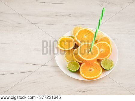 Plate With Cut Citrus And Straw On Wooden Background With Copy Space