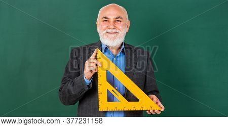 Senior Man Teacher Use Math Triangle Tool. Bearded Tutor Man At Blackboard. Back To School. Math Sci