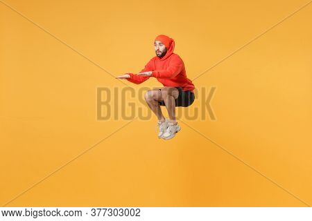 Young Bearded Fitness Sporty Guy 20s Sportsman In Hat, Hoodie, Shorts Spend Weekend In Home Gym Isol