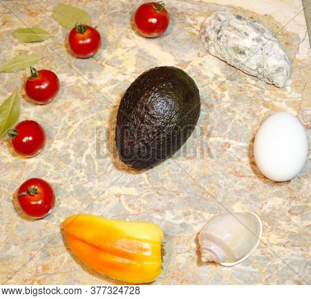Vegetables, Seashells, Egg And Avocado On A Marble Surface: Cherry Tomatoes, Bell Peppers, Bay Leave