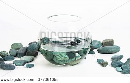 Sea Stones Turquoise In Water In A Glass Vase On A White Background