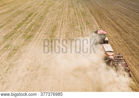 Aerial View. Tractor With Seed Drill Machine Sowing The Seeds For Crops In Spring Season. Beginning 