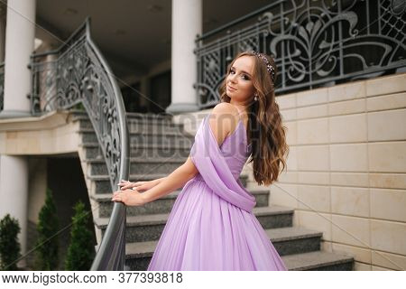 Portrait Of Elegant Woman In Purple Evening Dress Walking Outdoors By Restaurant
