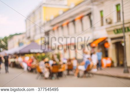 Blurred Background With Group Of Peolple Sitting At The Cafe Veranda Outside.