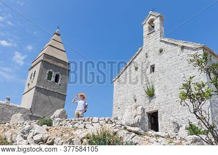 Female Traveler Sightseeing In An Ancient Costal Village Of Lubenice On The Island Of Cres, Croatia
