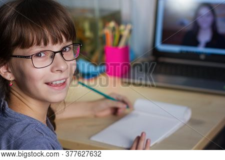 Distance Learning Online Education. A Happy Girl Studies At Home And Does School Homework