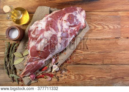 A Raw Leg Of Mutton On A Bone Lies On A Piece Of Burlap , Onions, Garlic, Pepper, Salt, Rosemary And