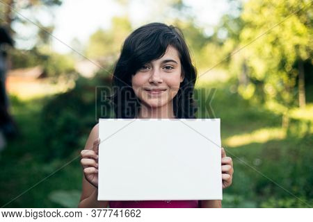 Teengirl holding clean white sheet paper (banner for your message)