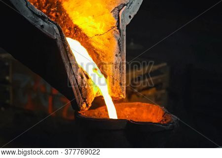 Molten Metal Flows Out Of A Furnace In A Smelter.