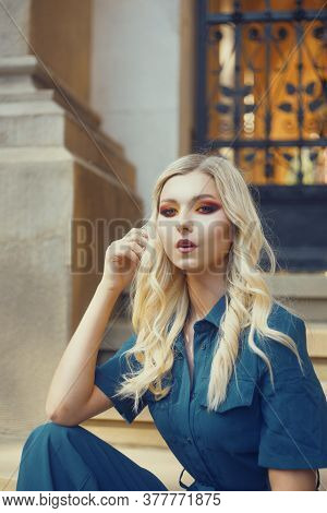 Blonde With Beautiful Smoky Eyes Makeup. Bright Red Shadows On A Beautiful Female Face. A Model On T