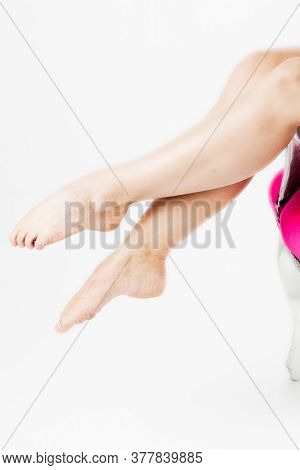 Long Smooth Sexy Female Legs Sensually Sitting In A Pink Chair. High Quality Photo