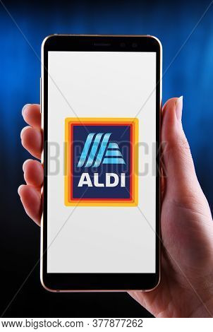Hands Holding Smartphone Displaying Logo Of Aldi
