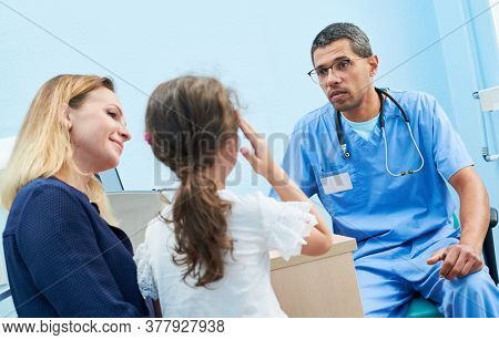 Medical examination of little girl by african doctor