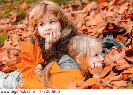 Little Boy And Girl Dreaming In Autumn Park. Colorful Foliage, Maple Leaves. Kid Dreams On Autumn Na
