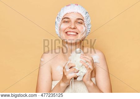 Satisfied Positive Smiling Female Dressed Bath Cap Looking At Camera With Toothy Smile Holding Spong