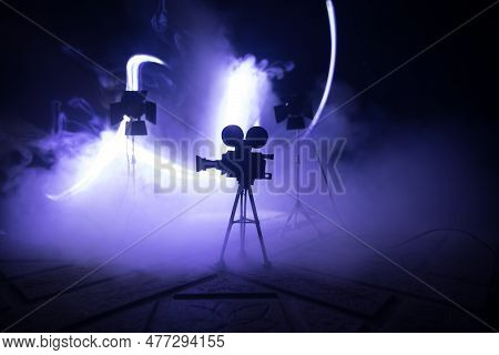 Movie Concept. Miniature Movie Set On Dark Toned Background With Fog And Empty Space. Silhouette Of