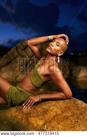 Gay Black Lgbtq Man Poses On Stone In Lake At Night Wearing Cocktail Dress, Handmade Boutique Jewelr