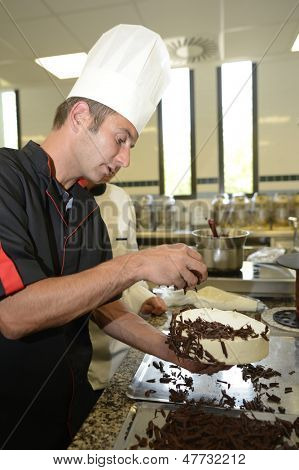 Pasticcere insegnante rendendo la torta al cioccolato