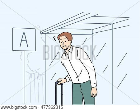 Confused Man With Suitcase Waiting On Bus Stop For Public Transport. Frustrated Male Traveler Expect