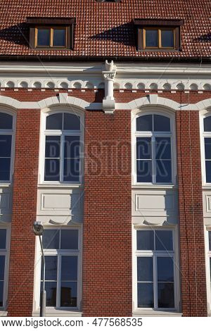 The Facade Of A Historic Building Built Of Red Brick In The Neo-gothic Style.
