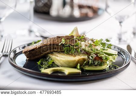Salad With Artichoke And Avocade With Marinated Tofu On Top Of It.