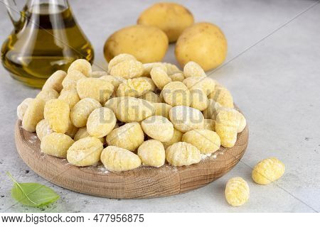 Uncooked Italian Potato Gnocchi On Gray Background With Ingredients. Italian Food.