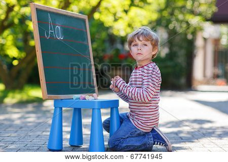 Little Boy At Blackboard Practicing Mathematics