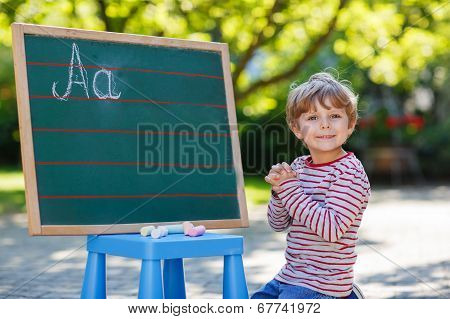 Little Boy At Blackboard Practicing Mathematics