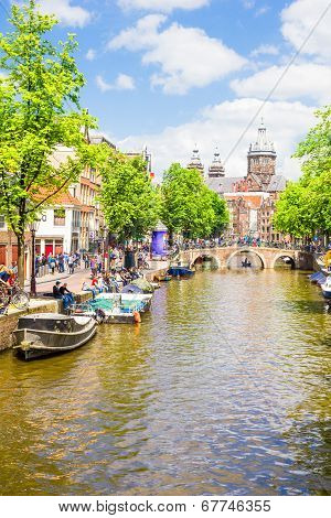 Tourists Walking By A Canal In Amsterdam