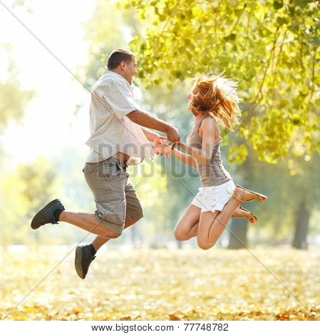 Happy Couple Jamping In The Park