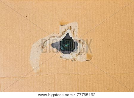 Hidden camera in torn hole in cardboard paper