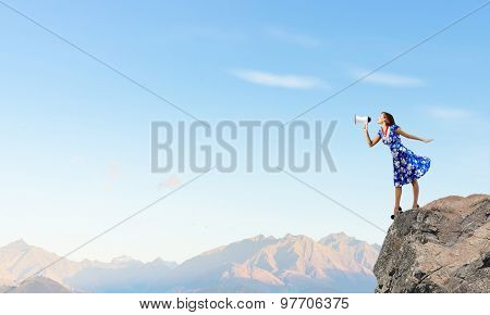 Young woman making some announcement in trumpet