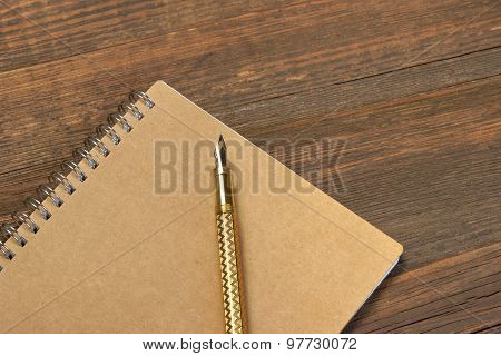 Notepad With Gold Fountain Pen On The Old Wood Table