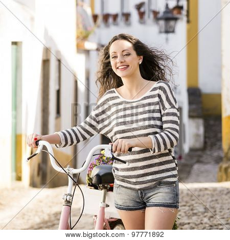 Happy beautiful female tourist riding a bicycle 