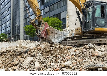 Bucket of a large excavator on a pile of construction debris