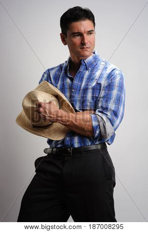 The handsome cowboy holds on to his hat.