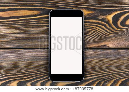 Mobile phone with blank screen mock up isolated on wood table background. Smartphone on wood table. Smartfone white