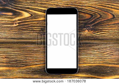 Mobile phone with blank screen mock up isolated on wood table background. Smartphone on wood table. Smartfone white