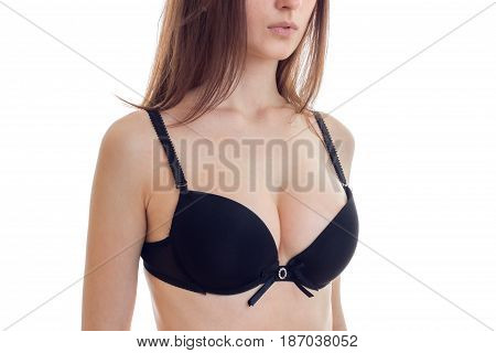 natural big sexy breasts in a black bra close-up isolated on white background