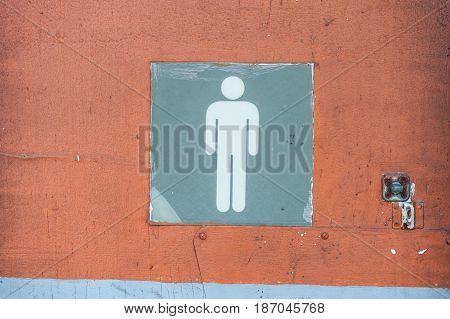 Men's bathroom sign in an old abandoned gas station with cracked paint.