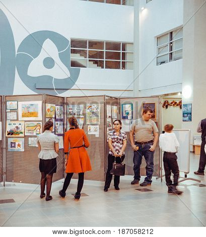 Udomlya City, Russia - 25 December 2015: Children watching the exhibition of drawings.