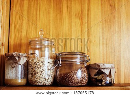 real comfort wooden kitchen with breakfast ingredients close up in glass, honey, oatmeal, milk, muesli