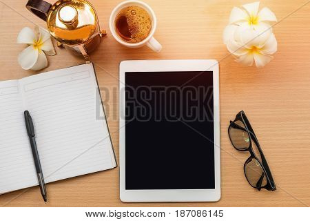 sunrise office with wooden table and laying on it with coffie