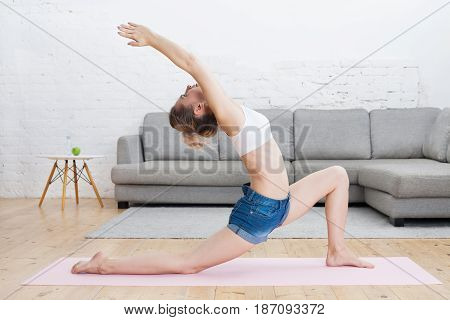 Young Beautiful Woman Doing Low Lunge With Upward Stretch / Urdhva Ashva Sanchalasana On Pink Mat At
