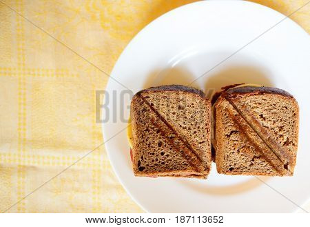 toasted ham and cheese sandwich on a white circular plate