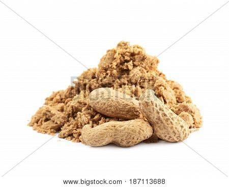 Pile of crushed and crumbled turkish halva confection next to a couple of peanuts, composition isolated over the white background