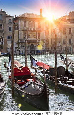 A sunset over the channel and gondolas Venice Italy