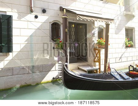 Gondola in the channel at house steps bright sunny day.