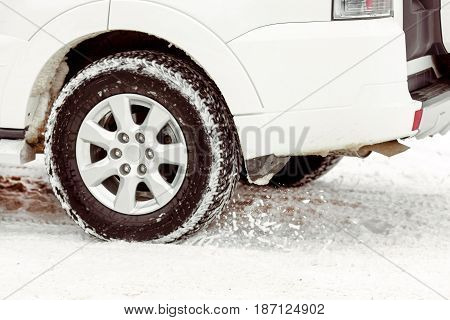 The wheel from the car on a winter road close up. Driving SUV car in winter on forest road with much snow